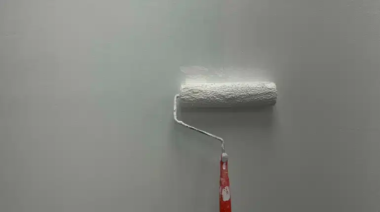 Paint roller against white wall